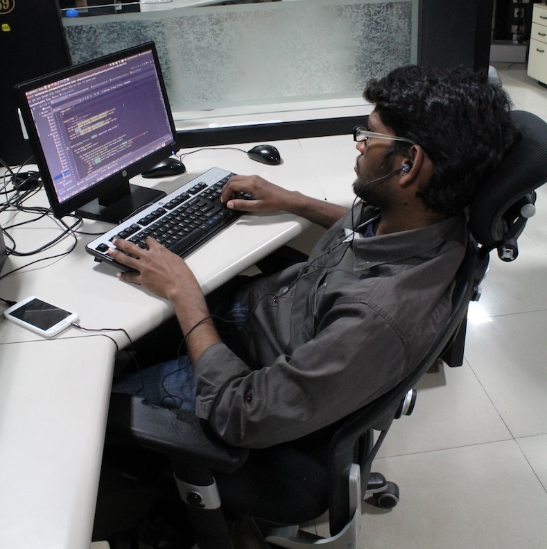 Profile Picture of Adrián Moreno (@zetxek), working side by side with a colleague: sitting on a desk, while looking at a screen